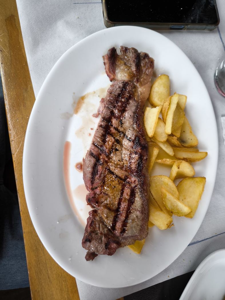 Entrecot a la parrilla con patatas fritas, servido en una tabla.